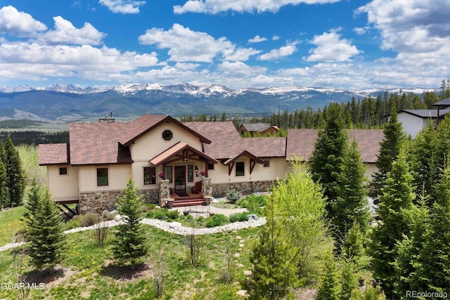 2621 Gcr 519, Tabernash, CO 80478 - view of front of home featuring stone siding, a mountain view, stucco siding, and a chimney