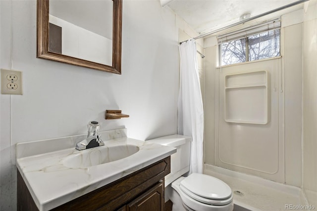 bathroom featuring a stall shower, vanity, and toilet