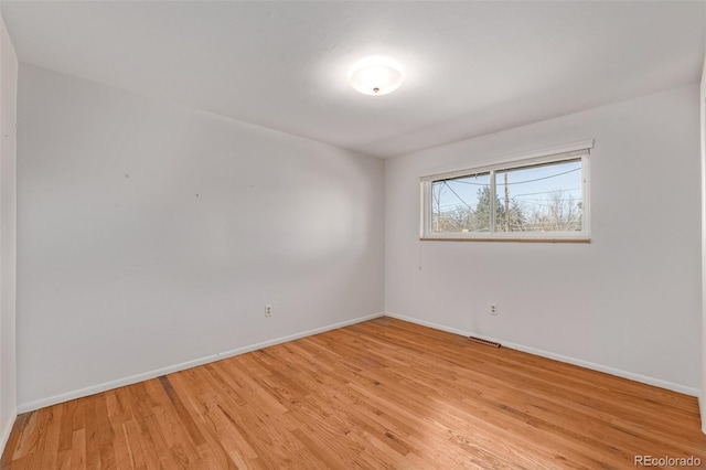 empty room featuring baseboards and light wood-style floors