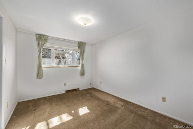 carpeted empty room featuring visible vents and baseboards