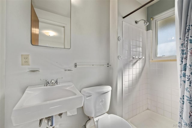 bathroom with a stall shower, a sink, and toilet