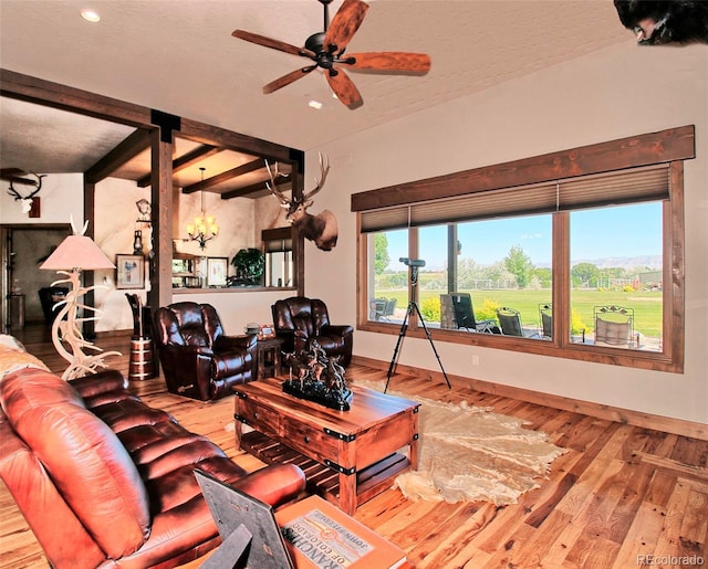 living room with beamed ceiling, ceiling fan, wood-type flooring, and baseboards