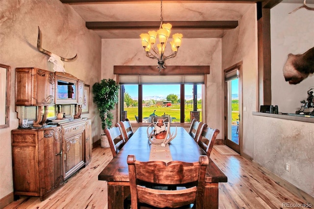 dining room featuring beam ceiling, a towering ceiling, an inviting chandelier, and light wood-style floors