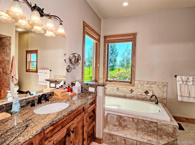 bathroom with recessed lighting, vanity, a garden tub, and toilet
