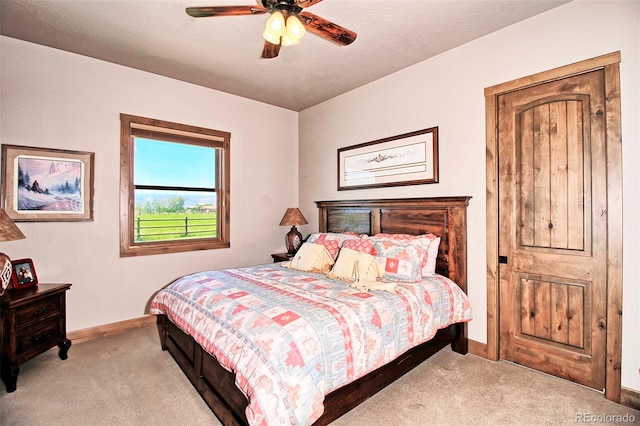 carpeted bedroom featuring ceiling fan and baseboards