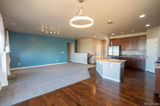 1985 Reed Grass Way, Colorado Springs, CO 80915 - kitchen with freestanding refrigerator, open floor plan, hanging light fixtures, dark wood-style floors, and recessed lighting
