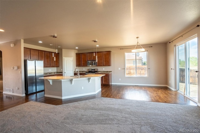 1985 Reed Grass Way, Colorado Springs, CO 80915 - kitchen featuring appliances with stainless steel finishes, dark wood-type flooring, light countertops, recessed lighting, and an island with sink