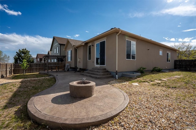 1985 Reed Grass Way, Colorado Springs, CO 80915 - back of house featuring a fenced backyard, stucco siding, a fire pit, and a patio