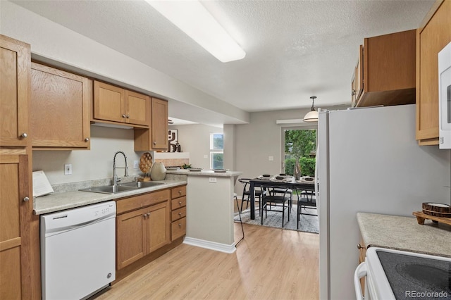 4109 Sunny Vista Hts, Colorado Springs, CO 80918 - kitchen with white dishwasher, light wood finished floors, light countertops, a textured ceiling, and brown cabinets
