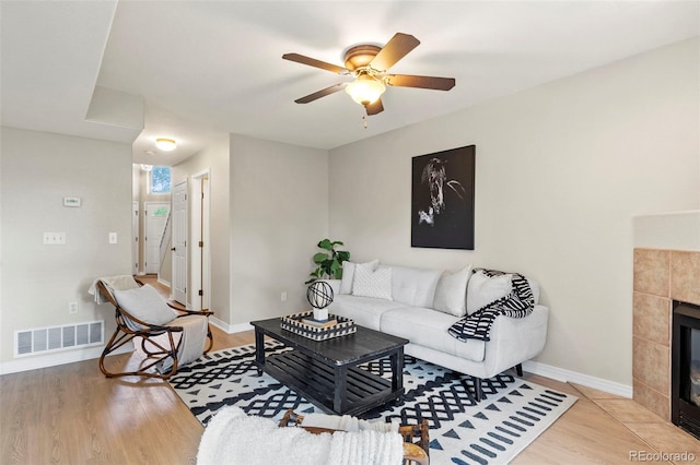 4109 Sunny Vista Hts, Colorado Springs, CO 80918 - living area with light wood-style floors, ceiling fan, and a tiled fireplace