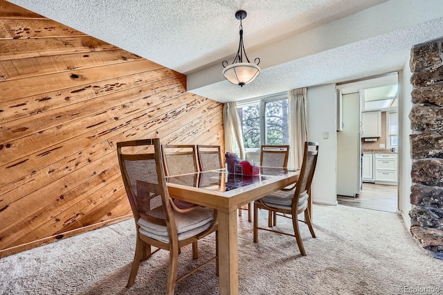 4484 Juniper Ct, Larkspur, CO 80118 - dining area featuring light carpet, wooden walls, and a textured ceiling