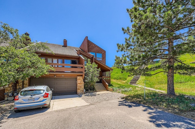 4484 Juniper Ct, Larkspur, CO 80118 - view of front of house featuring a garage, stone siding, stairway, driveway, and roof with shingles