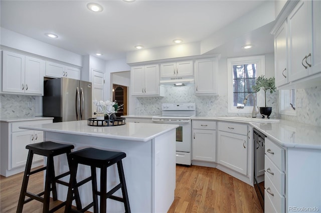 kitchen with white cabinetry, sink, stainless steel fridge, and white range with electric cooktop