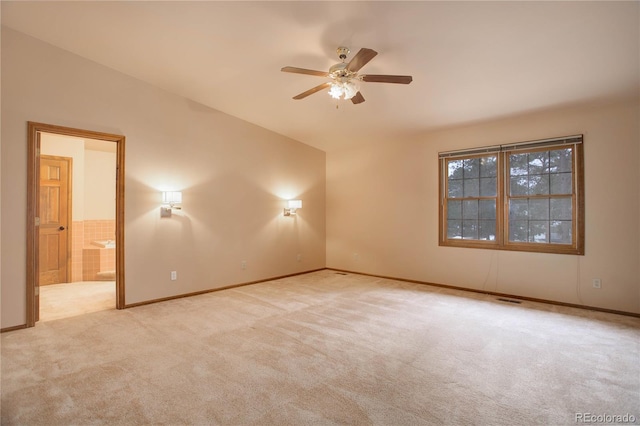 carpeted spare room featuring ceiling fan and lofted ceiling