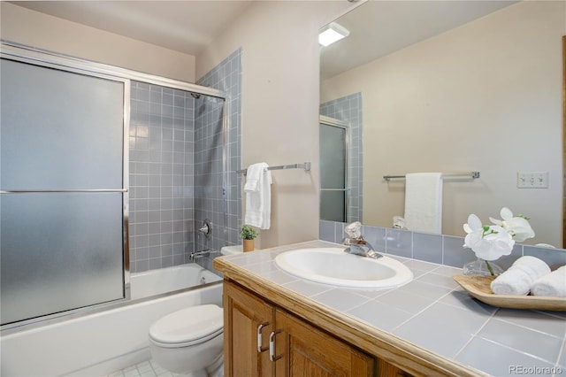 full bathroom with vanity, shower / bath combination with glass door, and toilet