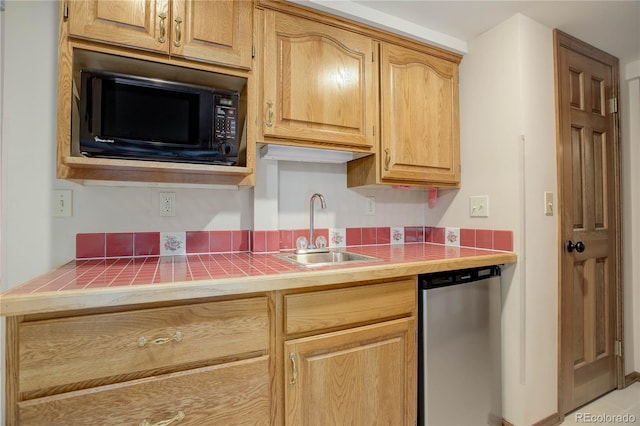 kitchen featuring black microwave, dishwasher, sink, and tile countertops