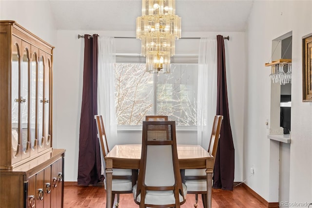 dining room with hardwood / wood-style floors and a chandelier