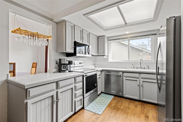 kitchen with light hardwood / wood-style flooring, sink, gray cabinets, and appliances with stainless steel finishes