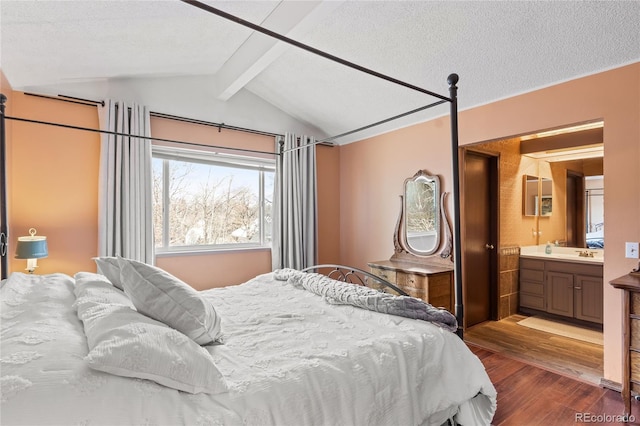 bedroom with sink, hardwood / wood-style floors, connected bathroom, lofted ceiling with beams, and a textured ceiling