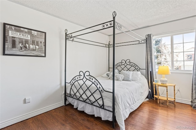 bedroom featuring wood-type flooring and a textured ceiling