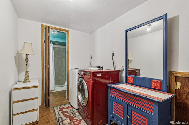 washroom featuring washing machine and dryer and dark hardwood / wood-style flooring