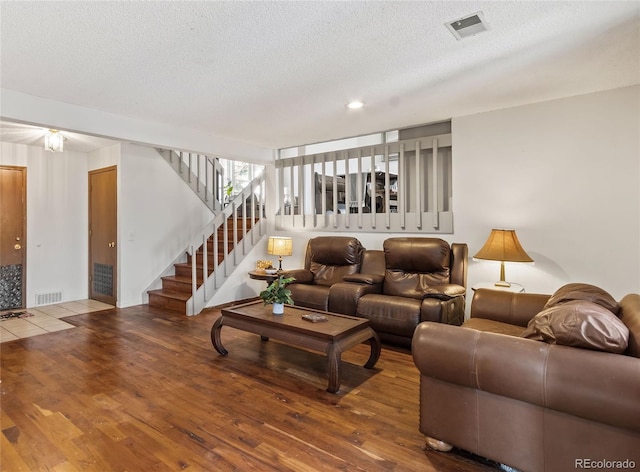 living room with wood-type flooring and a textured ceiling