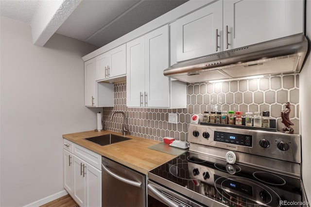 kitchen featuring sink, wooden counters, stainless steel appliances, white cabinets, and decorative backsplash