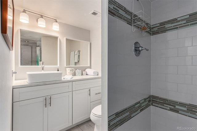 bathroom with vanity, toilet, and tiled shower