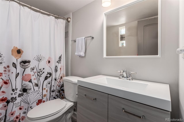 bathroom featuring toilet, curtained shower, and vanity