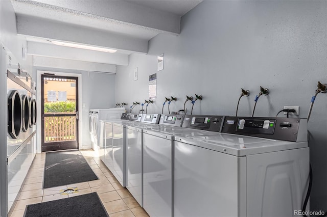 laundry room with independent washer and dryer and light tile patterned flooring