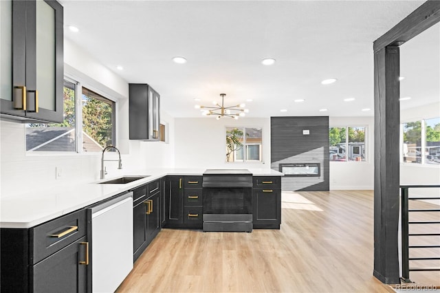 220 S Raleigh St, Denver, CO 80219 - kitchen with dishwasher, range, dark cabinets, light wood-style flooring, and a peninsula