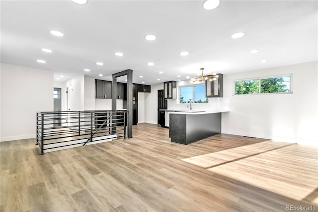 220 S Raleigh St, Denver, CO 80219 - kitchen with a peninsula, a chandelier, light wood-style flooring, light countertops, and recessed lighting