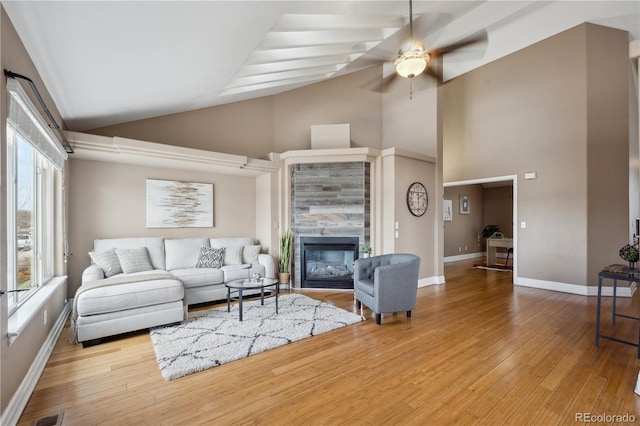 6595 Meade Ct, Arvada, CO 80003 - living room featuring high vaulted ceiling, ceiling fan, a tile fireplace, wood finished floors, and baseboards