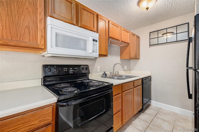 kitchen featuring light countertops, a sink, a textured ceiling, and black appliances