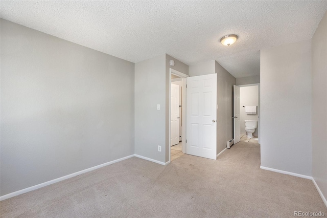 unfurnished bedroom with light carpet, a textured ceiling, and baseboards