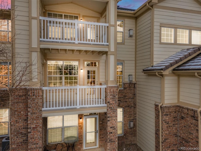 rear view of house featuring a balcony and central air condition unit