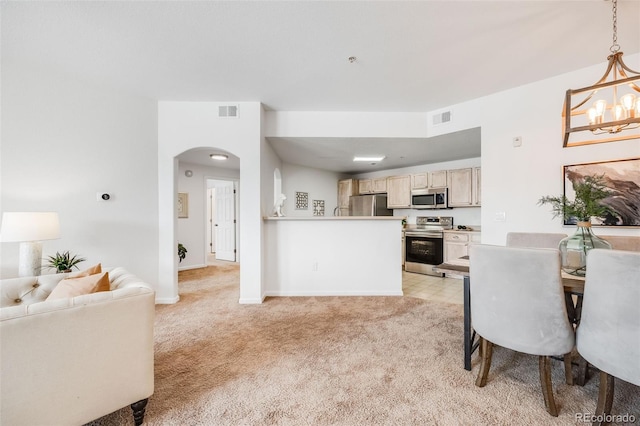 kitchen featuring appliances with stainless steel finishes, open floor plan, light carpet, and visible vents