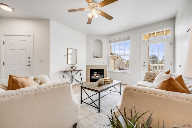 living area featuring a ceiling fan and a fireplace