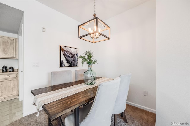 carpeted dining room featuring an inviting chandelier and baseboards