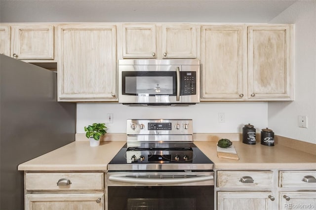 kitchen with stainless steel appliances, light countertops, and light brown cabinets