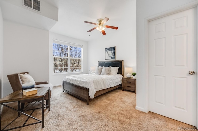 bedroom featuring a ceiling fan, light carpet, visible vents, and baseboards