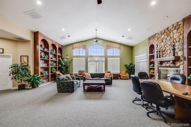 carpeted home office featuring visible vents, a fireplace, high vaulted ceiling, and a ceiling fan