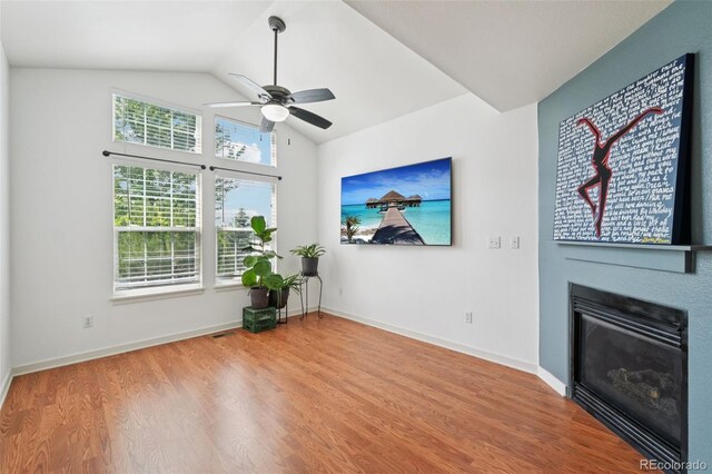 2408 Concord Cir, Lafayette, CO 80026 - unfurnished living room with ceiling fan, wood finished floors, a glass covered fireplace, and lofted ceiling