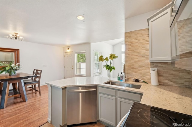 2408 Concord Cir, Lafayette, CO 80026 - kitchen with stainless steel dishwasher, a peninsula, tasteful backsplash, light stone countertops, and gray cabinets