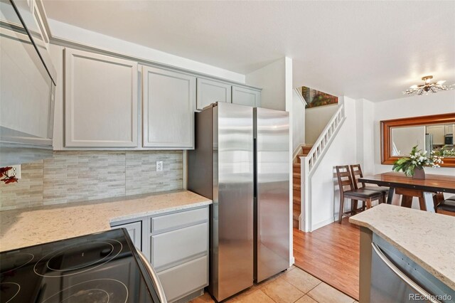 2408 Concord Cir, Lafayette, CO 80026 - kitchen with appliances with stainless steel finishes, gray cabinetry, backsplash, and light tile patterned flooring