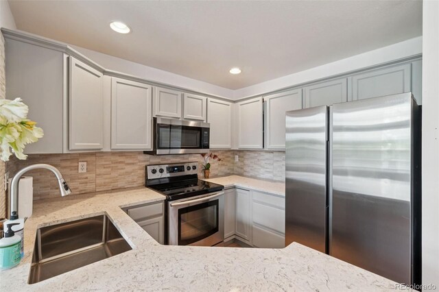 2408 Concord Cir, Lafayette, CO 80026 - kitchen featuring appliances with stainless steel finishes, light stone countertops, backsplash, gray cabinetry, and recessed lighting