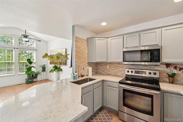 2408 Concord Cir, Lafayette, CO 80026 - kitchen featuring appliances with stainless steel finishes, gray cabinets, ceiling fan, vaulted ceiling, and backsplash