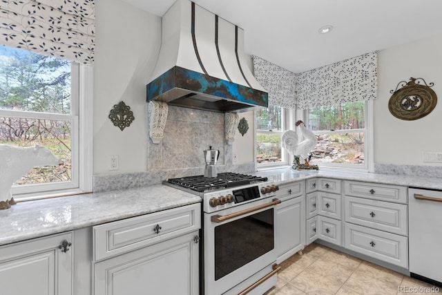 689 Red Deer Rd, Franktown, CO 80116 - kitchen featuring white appliances, premium range hood, white cabinets, backsplash, and light tile patterned floors
