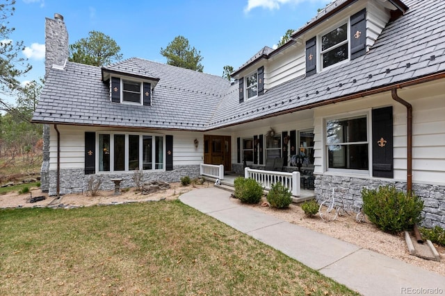 689 Red Deer Rd, Franktown, CO 80116 - view of front of property with a porch, stone siding, a chimney, and a front yard