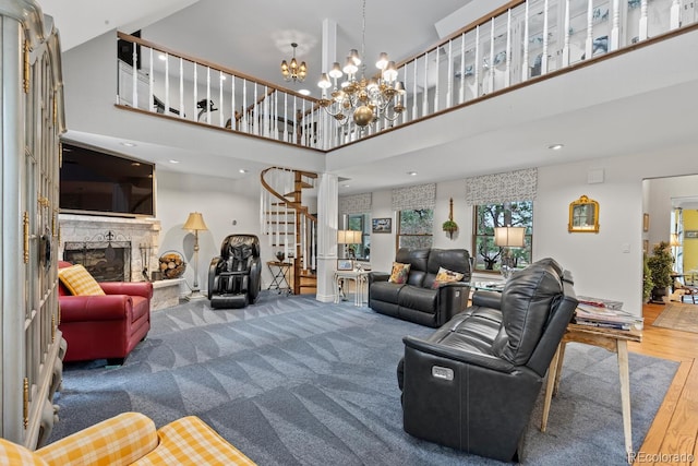 689 Red Deer Rd, Franktown, CO 80116 - living room featuring stairway, a high ceiling, a fireplace with raised hearth, wood finished floors, and a chandelier